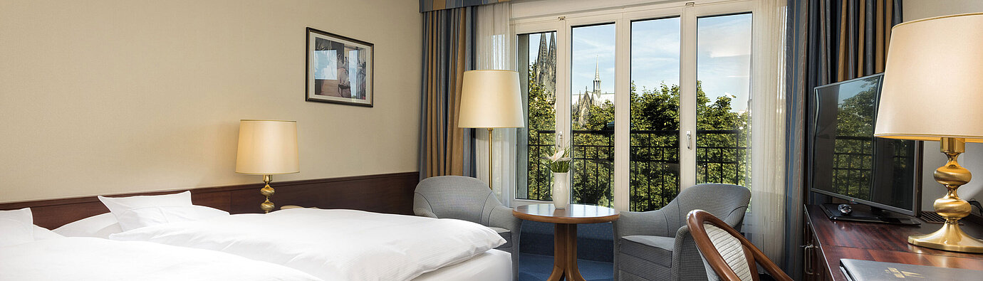 Chambre double supérieure à l'hôtel Maritim Cologne avec décor confortable et vue sur la cathédrale de Cologne.